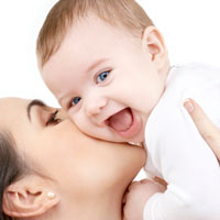 A woman kissing a happy baby