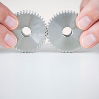 Hands holding a pair of gears