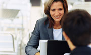 Two business people in meeting, woman using notebook