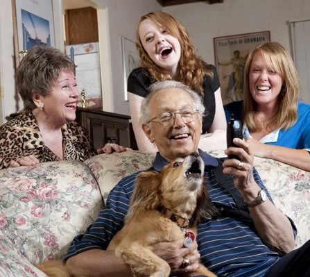 Grandparents laughing with granddaughters and the family dog