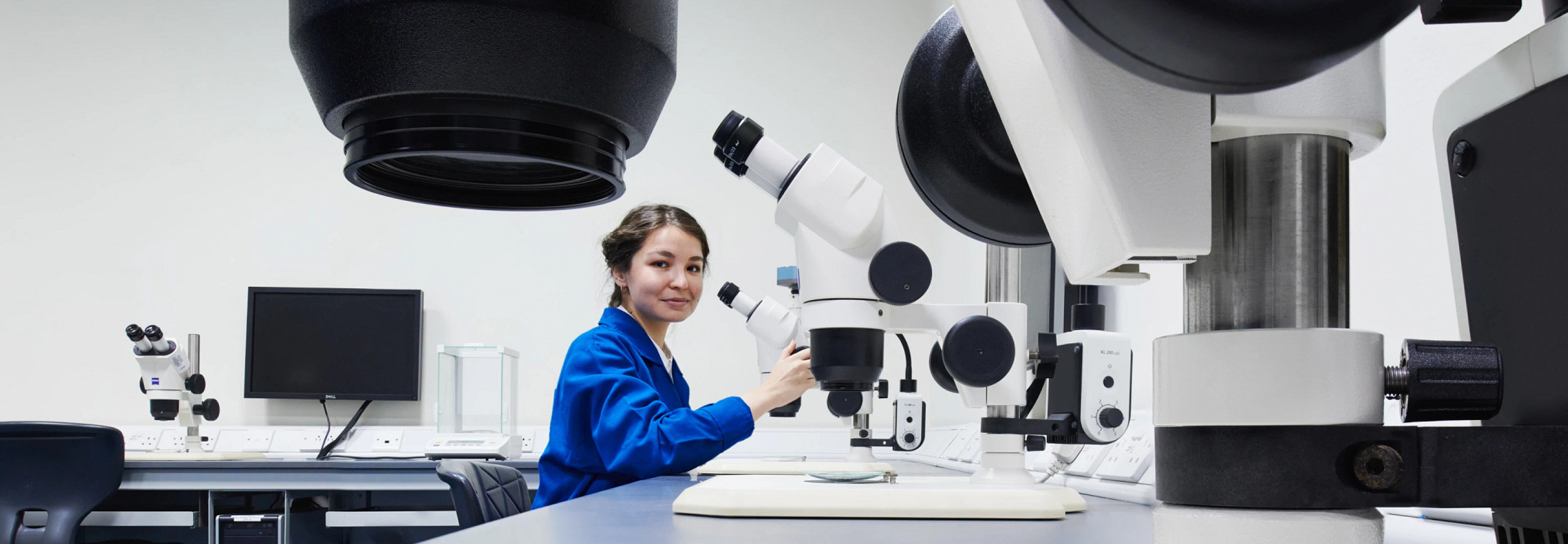 woman working with a microscope in a lab